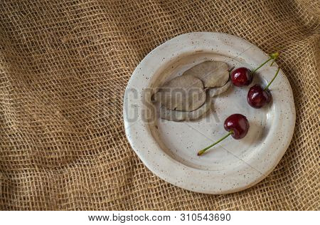 Ripe Sweet Cherry Lies With Eucalyptus Leaves On A Handmade Ceramic Plate, Gray, Flat Plate, Shot Fr