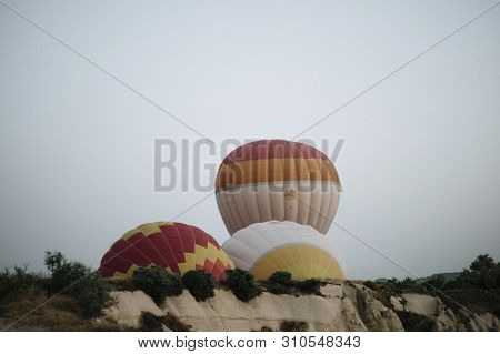Hot Air Balloons Landing In A Mountain Cappadocia Goreme National Park Turkey.