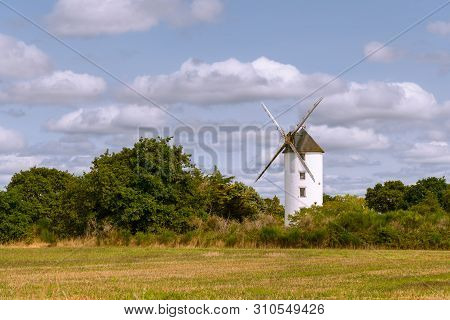 Old Windmill Standing In A Small Forest In Saint Lyphard (france)