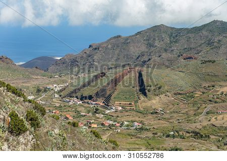 Valley Of El Palmar In The Teno Mountains With Green Slopes. In The Center - Volcanic Hill Like A Sl