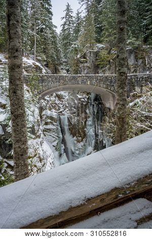 Brdige At Christine Falls Framed By Snowy Trees During Winter
