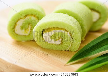 Pandan Roll Cake And Fresh Pandan Leaf On Wooden