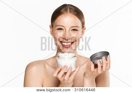 Image of cheerful half-naked woman holding bath salt jar and looking at camera isolated over white background