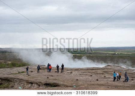 Tourists Visiting Strokkur Geyser In Iceland
