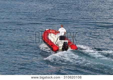 The Marina Staf Is Sailing On A Red Inflatable Motorboat To A Sailing Cruise Yacht Entering The Mari