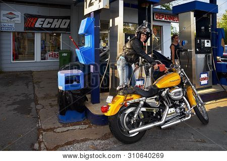 Montreal, Quebec, Canada, September 1, 2018. Woman Smiles Into The Camera, Refueling A Harley Davids