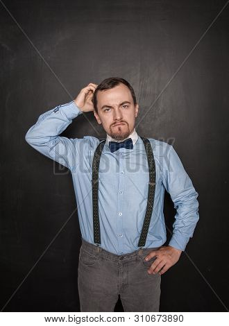 Handsome Business Man Scratching His Head On Blackboard