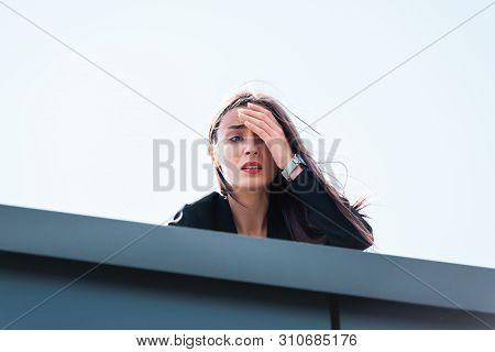 Frightened Businesswoman, Suffering From Acrophobia, Looking Down Rooftop And Covering Face With Han