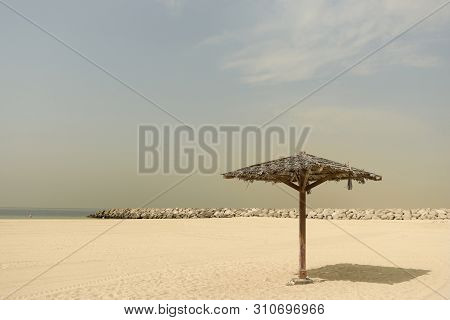 Thatched Parasol On An Empty Gold Beach. Vintage. Al Mamzar, Dubai, Emirates, Jul.2018
