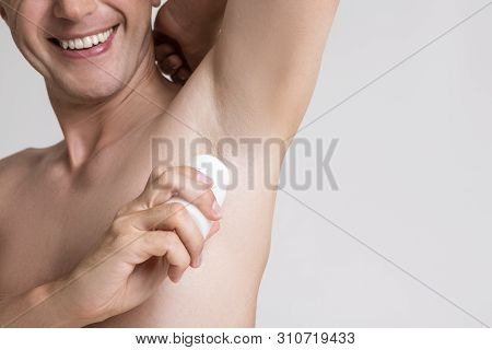 Handsome Caucasian Man Applying Underarm Deo Stick. Horizontal Image