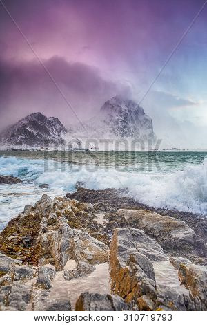 Arctic Ocean Near Rocky Shore Of Picturesque Lofoten Islands Against Snowy Mountains In Norway At Sp