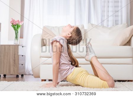 Female sportman doing excellent frog pose on the carpet
