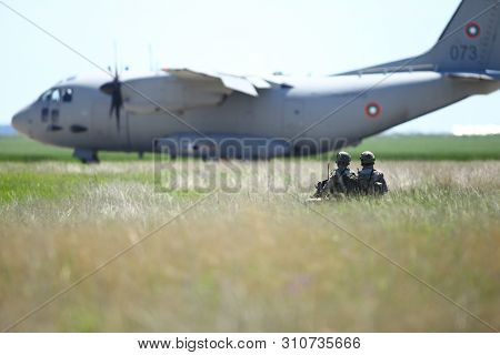 Boboc, Romania - May 22, 2019: Romanian Army Soldiers Patrol On A Military Air Base, With An Alenia 