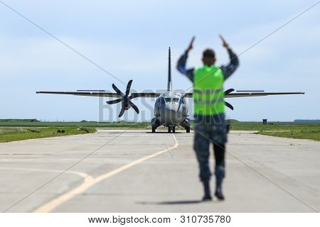 Boboc, Romania - May 22, 2019: Ground Personnel Is Aircraft Marshalling An Alenia C-27j Spartan Mili