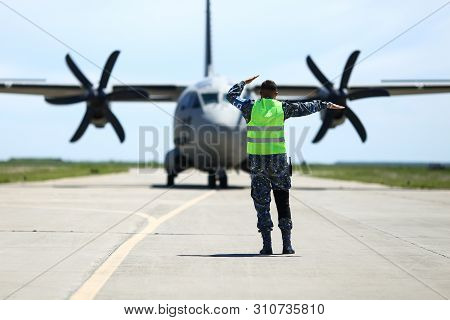 Boboc, Romania - May 22, 2019: Ground Personnel Is Aircraft Marshalling An Alenia C-27j Spartan Mili