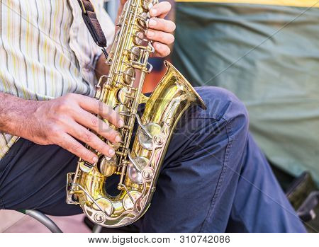 Street Musician Playing Saxophoneon A Sunnny Day