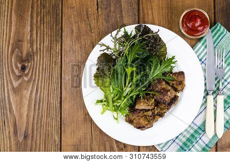 Slices Of Fried Liver, Green Leaves Of Salads