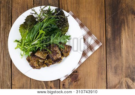 Slices Of Fried Liver, Green Leaves Of Salads