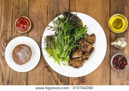 Slices Of Fried Liver, Green Leaves Of Salads