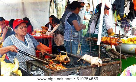 Cuenca, Ecuador - March 31, 2019: Vendor Woman Prepares Cuy Or Roasted Guinea Pig - Traditional Deli