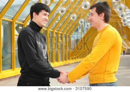 Apretón de manos de dos amigos en la pasarela