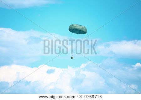 A Military Crate Is Being Parachuted From A Military Cargo Plane During A Drill.