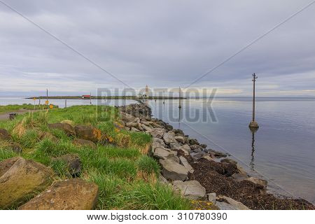 Electricity Pylons In The Water To The Island Of Grotta Near Reykjavik In The Morning With Clouds In
