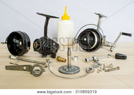A Fishing Spinning Reel As A Whole And A Second Similar Completely Disassembled. Concept: Parts Of A
