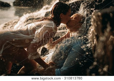 A Couple In Love During Lovemaking Under The Streams Of A Waterfall.