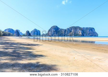 Boat On Rajamangala Beach With Limestone Cliffs In The Background,trang Province, Thailand