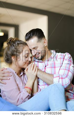 Young Pretty Boy Hugging Gilfriend Wearing Jeans.