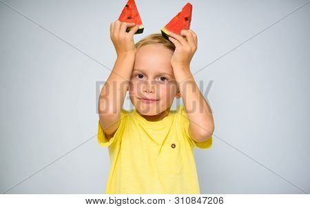 Frolicsome Caucasian 5 Year Old Boy Child In Yellow T-shirt Holding Two Pieces Of Red Watermelon Abo