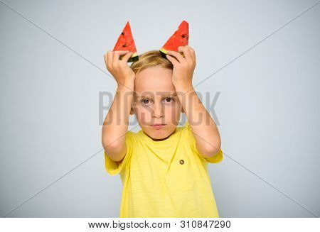 Frolicsome Caucasian 5 Year Old Boy Child In Yellow T-shirt Holding Two Pieces Of Red Watermelon Abo