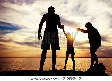 Happy Family Silhouette On The Sunset Background