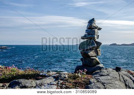 Looking At The Horizon. Stone Cairn On The Rocky Shore. Seascape With Rocky Islands. West Bank Flekk