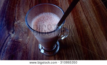 Glass With Tasty Chocolate Milk On Wooden Table, Space For Text. Dairy Drink