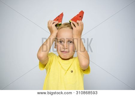 Frolicsome Caucasian 5 Year Old Boy Child In Yellow T-shirt Holding Two Pieces Of Red Watermelon Abo