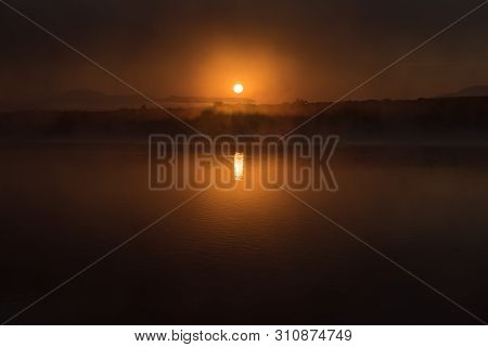 The Sun Rises Through The Fog On The Dam At Vrede, In The Free State Province