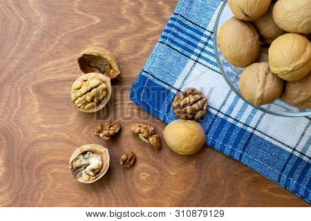 Whole Walnuts And Walnut Kernel Halves Without Shell On A Dark Wooden Table And Checkered Towel, Clo