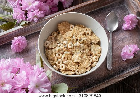 Breakfast Cereals In A Bowl On A Tray With Pink Kwanzan Cherry Blossoms, Top View