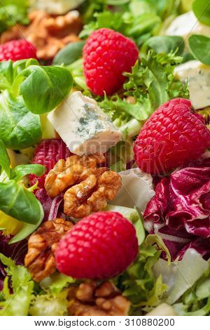 Green Salad With Slices Of Blue Cheese , Raspberries And Walnuts.