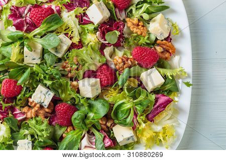 Green Salad With Slices Of Blue Cheese , Raspberries And Walnuts.