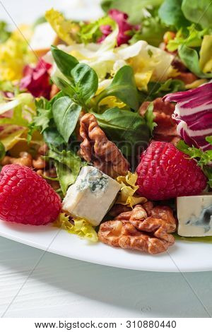 Green Salad With Slices Of Blue Cheese , Raspberries And Walnuts.