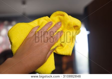 Hand Wiping A Layer Of Dust On The Furniture With Yellow Dry Reg. General Or Regular Cleaning. Comme