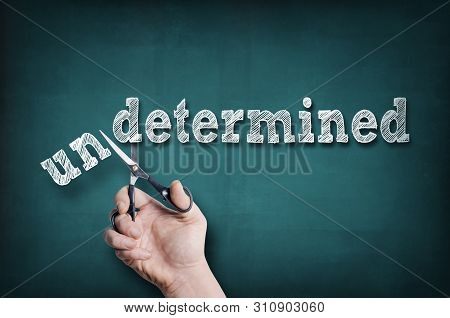 The Male Hand With Scissors Cuts Word Determined From Undetermined