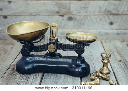 Antique Vintage Measuring Scale Weights With Brass Trays On The Wooden Rustic Background. Selective 