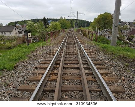 Old Railway For Transportation In Belarus By Summer Under Cloudy Sky With Rural Area Landscape Aroun