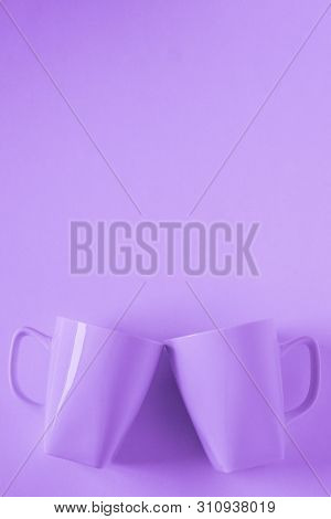 Purple Coffee Mugs On Purple Background Clinking In Cheers With Empty Copy Space
