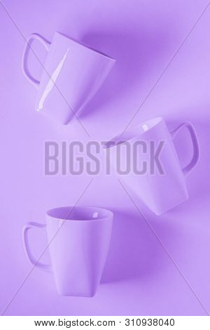 3 Purple Coffee Mugs On Purplish Background Scattered With Empty Copy Space