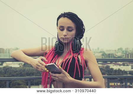 Trendy Teenage Girl Listening To Music On Headphones. Rock Style. Modern Generation. Woman With A Pi